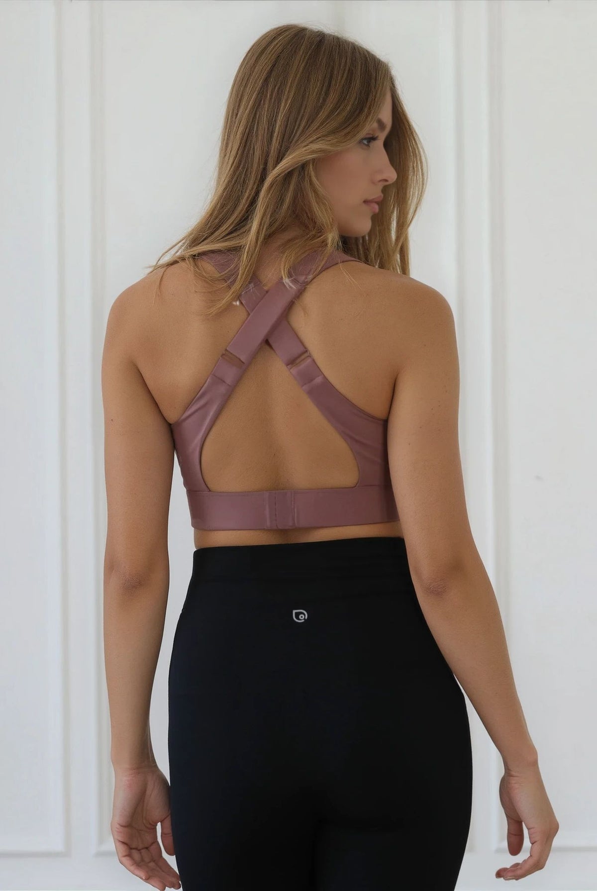 Woman wearing a mauve colored sports bra against a plain background, featuring a venice high impact nursing and pumping bra from sweat and milk