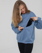 Close-up of the Isabella Nursing Sweatshirt in chambery blue with side zipper being opened, showing discreet nursing access, Sweat and Milk