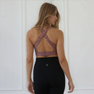 Woman wearing a mauve colored sports bra against a plain background, featuring a venice high impact nursing and pumping bra from sweat and milk
