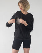 - Model lifting Ivy nursing top to show hidden nursing access panel
- Discreet nursing access on Ivy top – breastfeeding in style