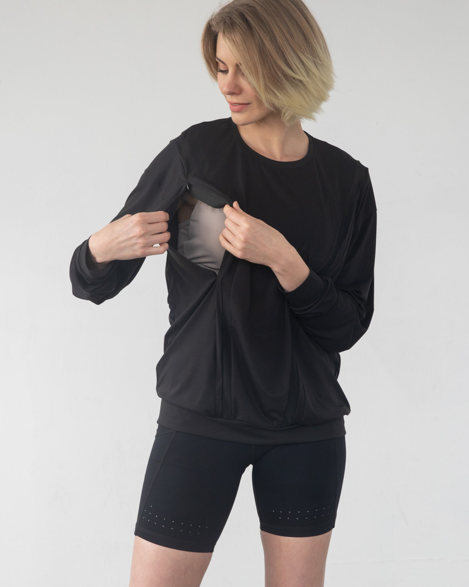 - Model lifting Ivy nursing top to show hidden nursing access panel
- Discreet nursing access on Ivy top – breastfeeding in style