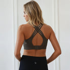 Woman wearing a black sports bra with criss-cross design on a white background, high-impact nursing sports bra, Chloe 4, Sweat and Milk