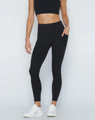 Postpartum ultra high waisted leggings, sweat and milk, with pockets, noir, front shot with both hands in pockets, half body