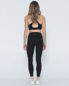 Postpartum ultra high waisted leggings, sweat and milk, with pockets, noir, back view shot with hands in pocket, full body