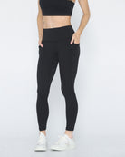 Postpartum ultra high waisted leggings, sweat and milk, with pockets, noir, front shot with both hands in pockets, half body