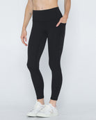 Postpartum ultra high waisted leggings, sweat and milk, with pockets, noir, front shot with hands in pocket, half body