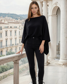 a woman wearing a cashmere poncho in black, nursing cover, noir, stroller blanket, travel cover, sweat and milk