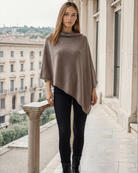 a woman wearing a cashmere poncho in taupe, nursing cover, noir, stroller blanket, travel cover, sweat and milk