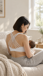 Mom nursing on the sofa in the Océane 4 nursing and pumping sports bra in Blanc